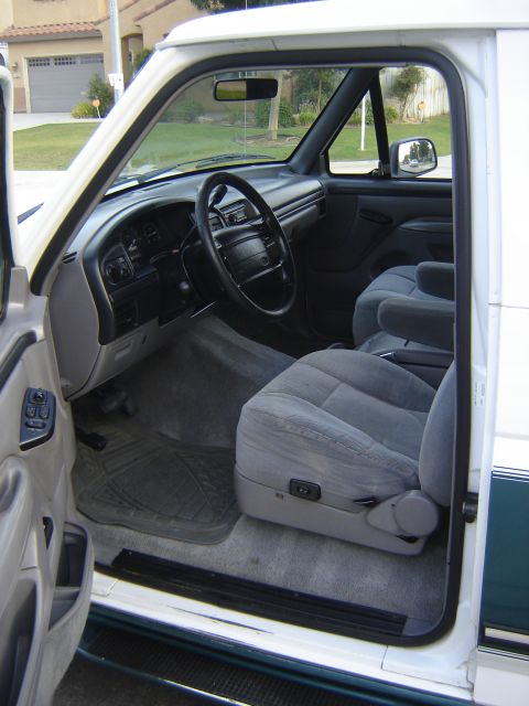 1996 Ford Bronco - The interior of a 1996 Ford Bronco features cloth seats and a gray dashboard.