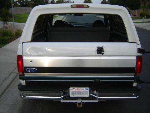 1996 Ford Bronco - The rear of a white Ford Bronco shows its distinctive body style and chrome bumper.