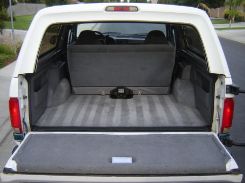 1996 Ford Bronco - Rear view of the cargo area of a 1996 Ford Bronco, showing the folded rear seats and the tailgate.
