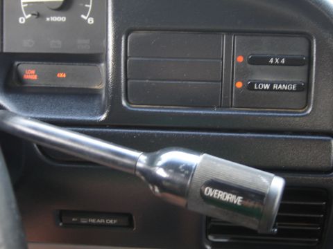 1996 Ford Bronco - Close-up of a vehicle's interior dashboard, showing the gear shifter and 4x4 controls.