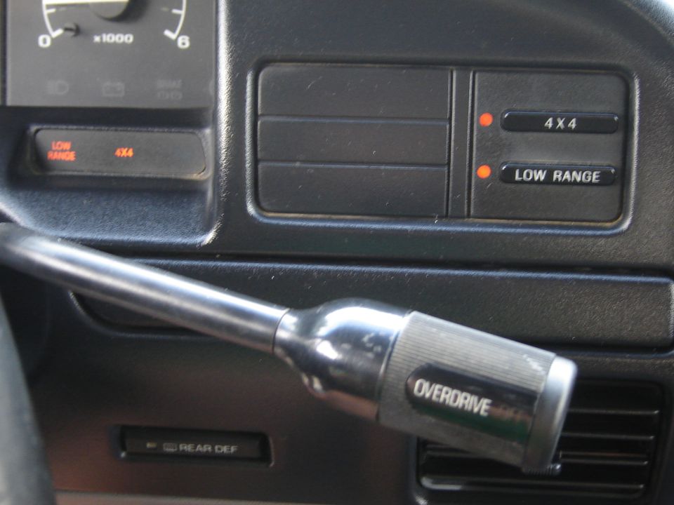 Gear shifter with 'OVERDRIVE' label, 4x4 and Low Range indicator lights, and part of the speedometer