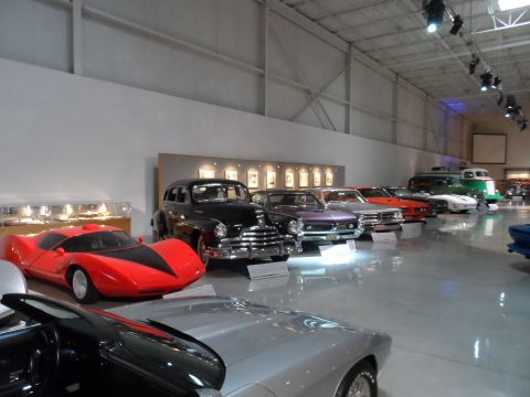 1971 Ford Ranchero - A red sports car with black accents is displayed in a museum alongside other vintage vehicles.
