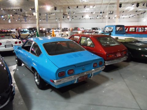 1971 Ford Ranchero - Multiple vehicles displayed indoors, including a blue coupe and a red hatchback.