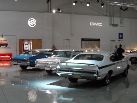 1971 Ford Ranchero - Museum exhibit multiple classic automobiles under bright lighting.
