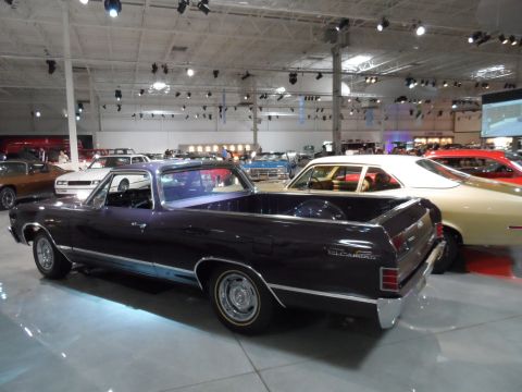 1971 Ford Ranchero - A dark purple 1968 Ford Ranchero is displayed indoors alongside other vehicles.