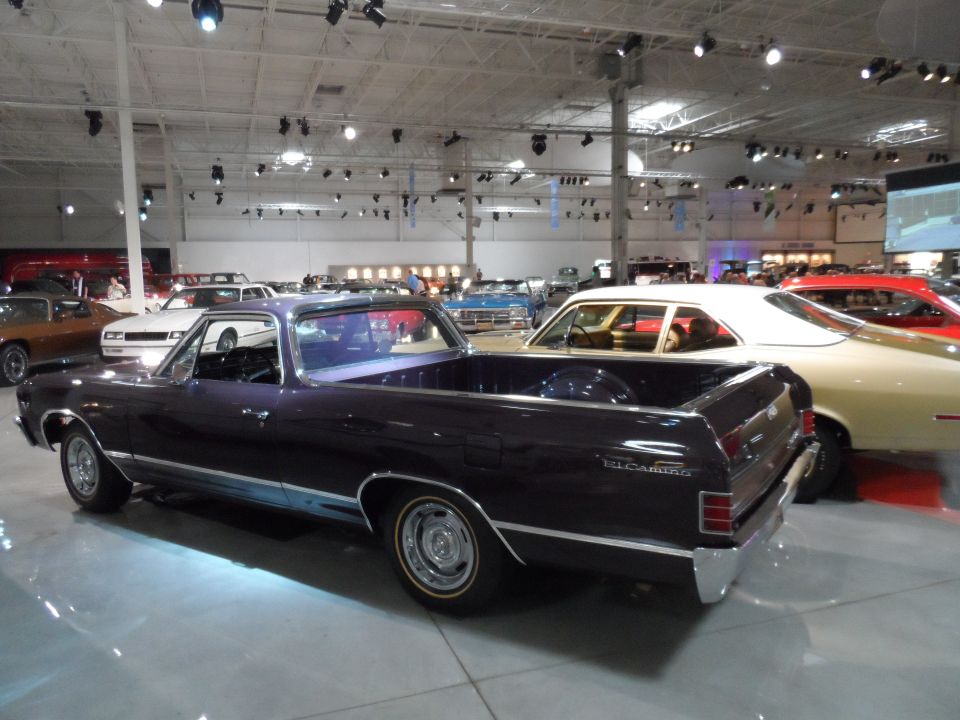 Dark purple 1968 Ford Ranchero pickup truck, rear quarter view, in a museum with other cars