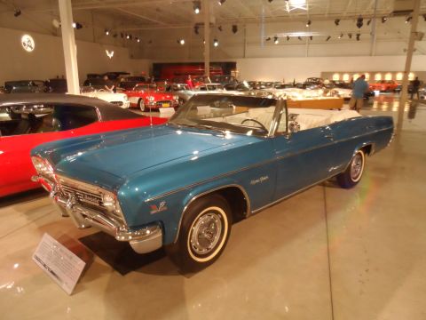 1971 Ford Ranchero - A blue convertible is displayed in a museum alongside other classic vehicles.