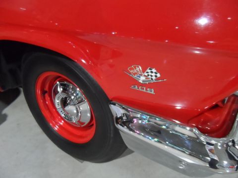 1971 Ford Ranchero - Close-up of a red car's fender, a "409" badge with a checkered flag emblem.
