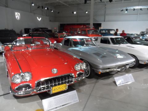 1971 Ford Ranchero - Two classic Chevrolet Corvettes are displayed indoors, with a red convertible in the foreground.
