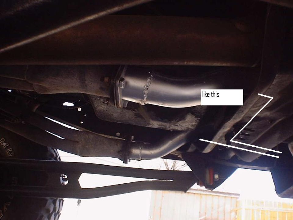 Underbody view of welded exhaust tubing routed past a truck frame rail, annotated 'like this'