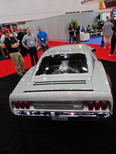1971 Ford Ranchero - A customized car with a prominent engine is displayed at an indoor event.