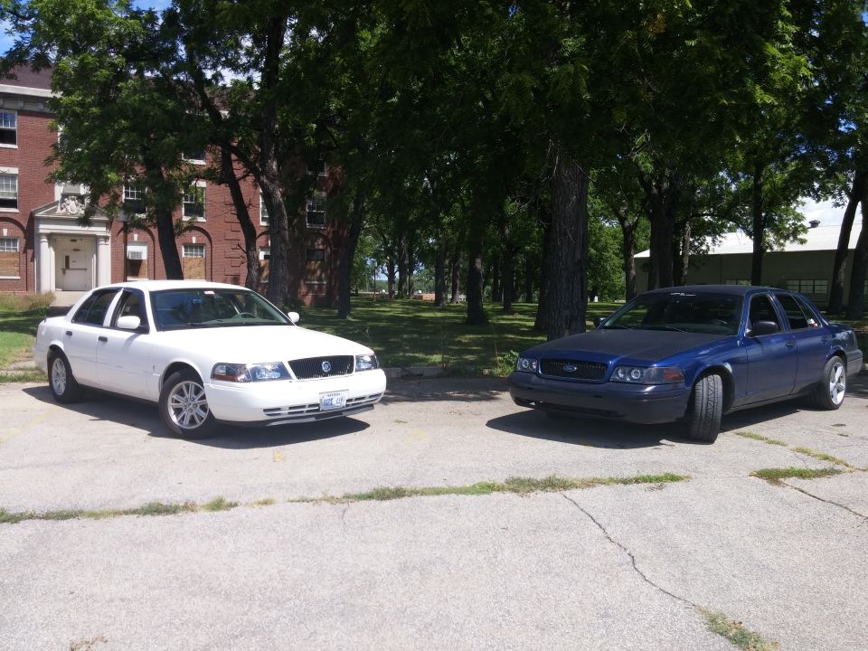 2000 Mercury Grand Marquis and a blue sedan parked on asphalt