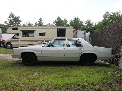1991 Ford LTD Crown Victoria - Side view of a 1991 Ford Crown Victoria LTD parked on grass.