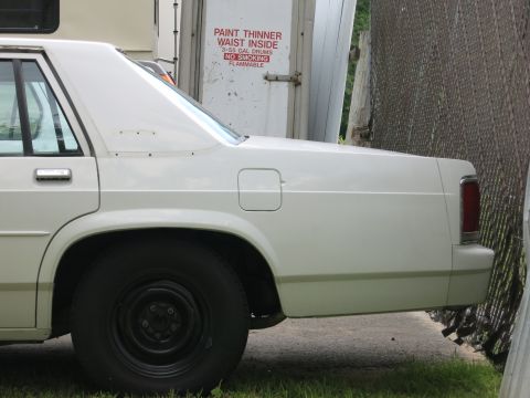 1991 Ford LTD Crown Victoria - Side view of a white 1991 Ford Crown Victoria LTD, showing its rear quarter panel and wheel.