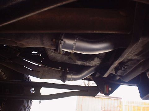 1988 Ford Bronco - The underside of a vehicle shows a custom exhaust system with new pipes and hangers.