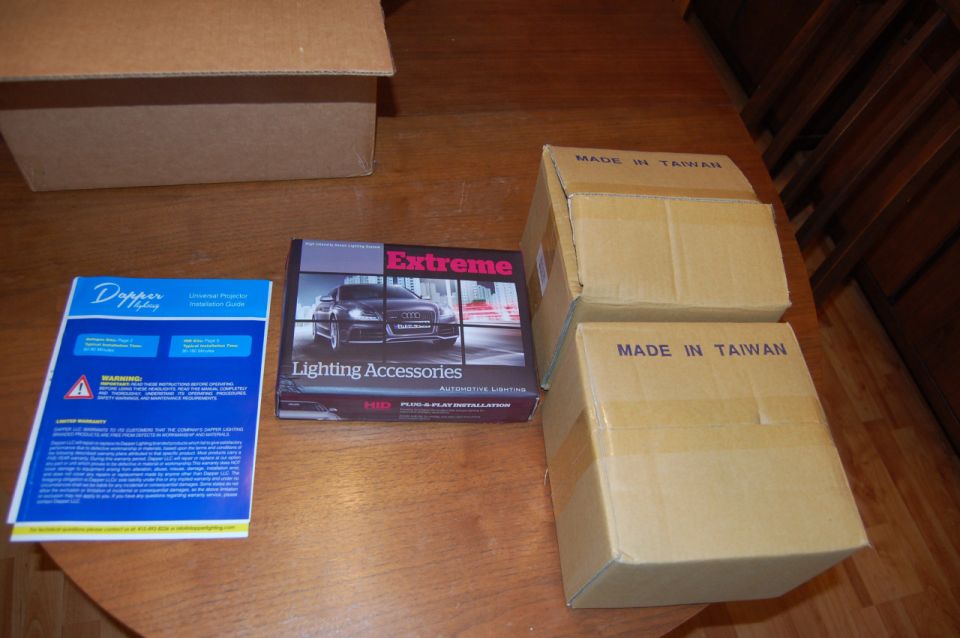 Cardboard boxes and packaging for Dapper Lighting and Extreme Lighting Accessories on a wooden table