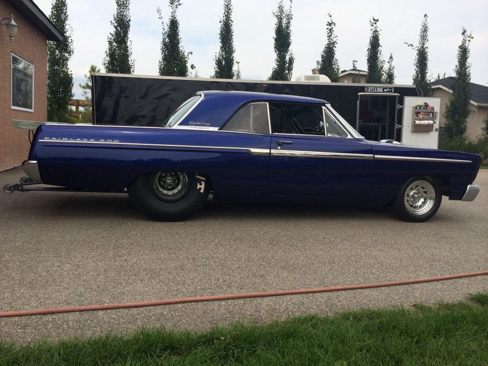 1965 Ford Fairlane drag car with large rear tires and a roll cage, parked outside