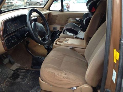 1989 Ford Bronco - The interior of a 1987 Ford Bronco shows a tan interior with a child seat installed.