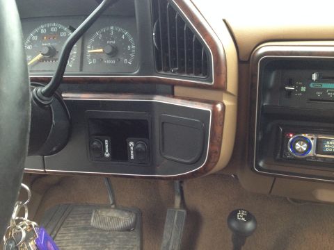 1989 Ford Bronco - The interior of a 1989 Ford Bronco shows its dashboard with gauges, wood trim accents, and an aftermarket stereo system.