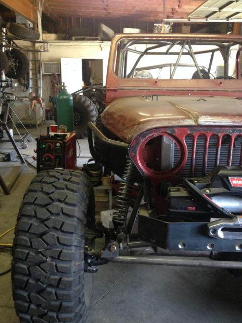 1985 Jeep CJ7 - This Jeep CJ-series features a custom roll cage and aggressive off-road tires, suggesting modifications beyond its original build.