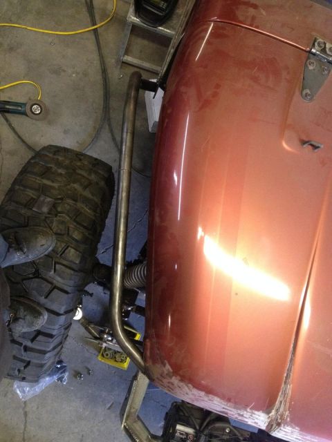 1985 Jeep CJ7 - Close-up of a Jeep's side panel and large tire, with a roll cage installed.