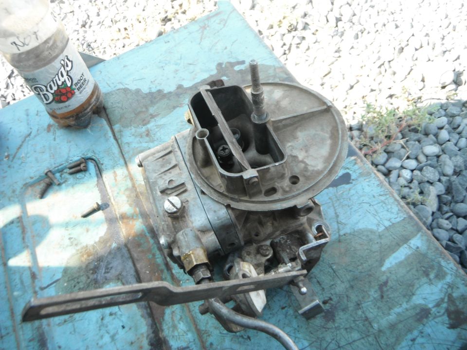 Carburetor on blue surface with Barg's Root Beer bottle