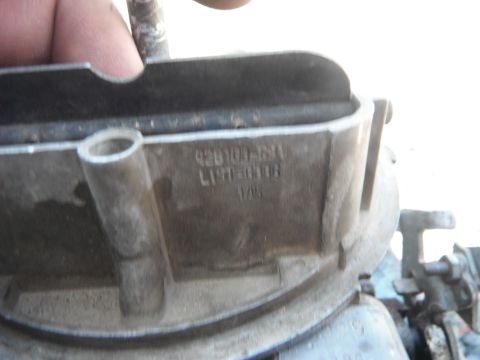 1972 International Scout II - A close-up shows a carburetor with stamped part numbers, likely from an older vehicle.
