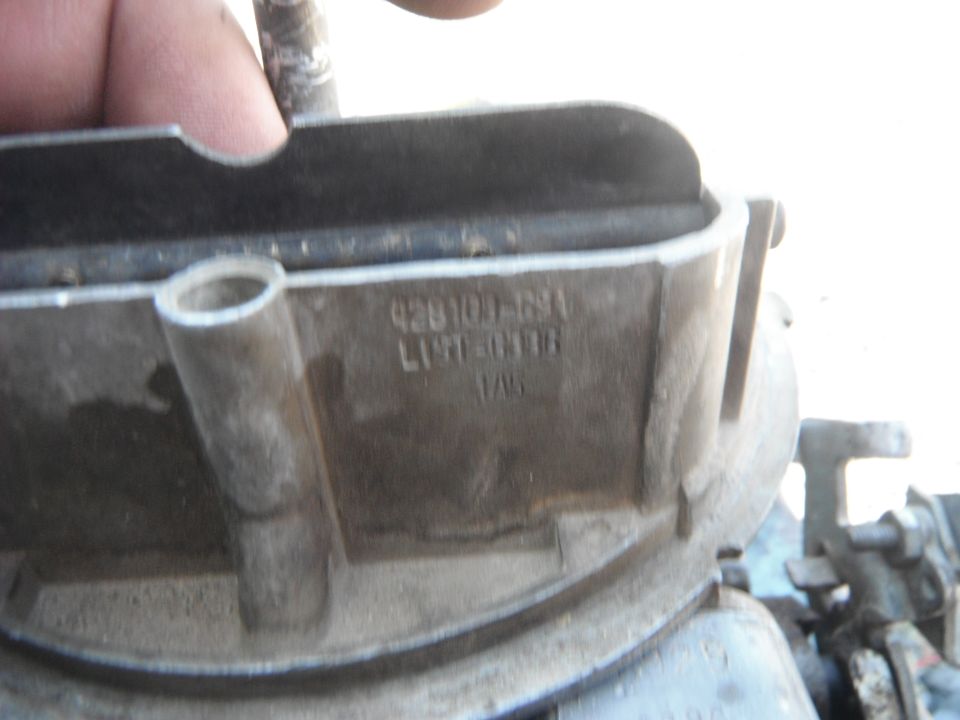 Close-up of a carburetor with part numbers visible