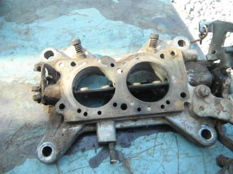 1972 International Scout II - A close-up view of a carburetor, showing its internal components and external mechanical parts.