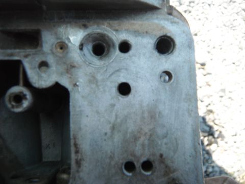 1972 International Scout II - A detailed view of a metal carburetor component, showing various holes and surface textures.