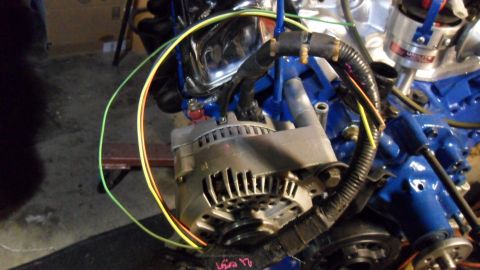 1972 Ford Ranchero - Close-up view of an engine's alternator and wiring harness against a blue painted engine block.