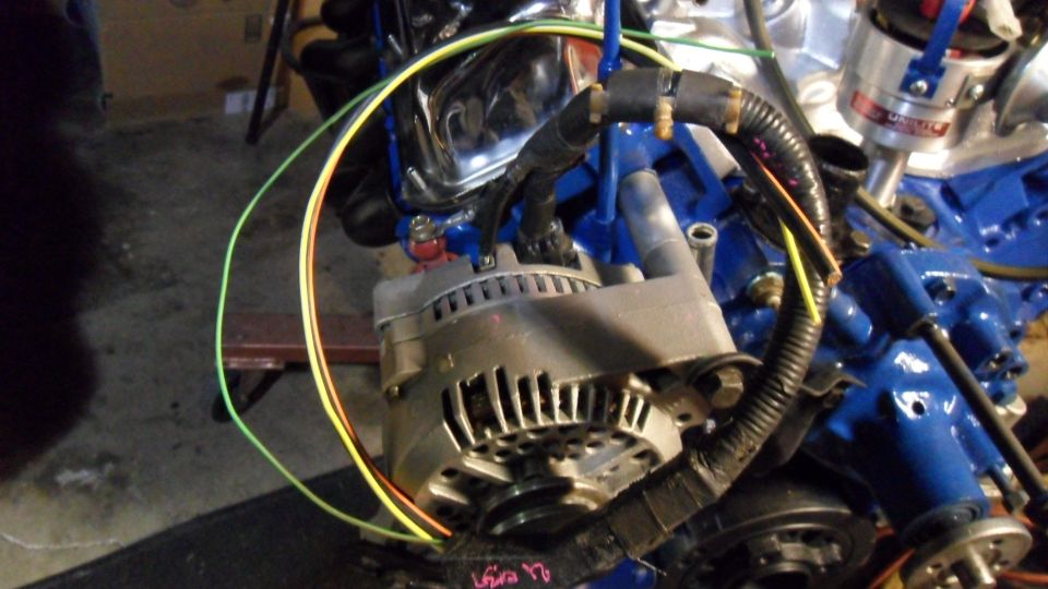 Engine alternator with blue painted block and chrome accents. Wires are connected