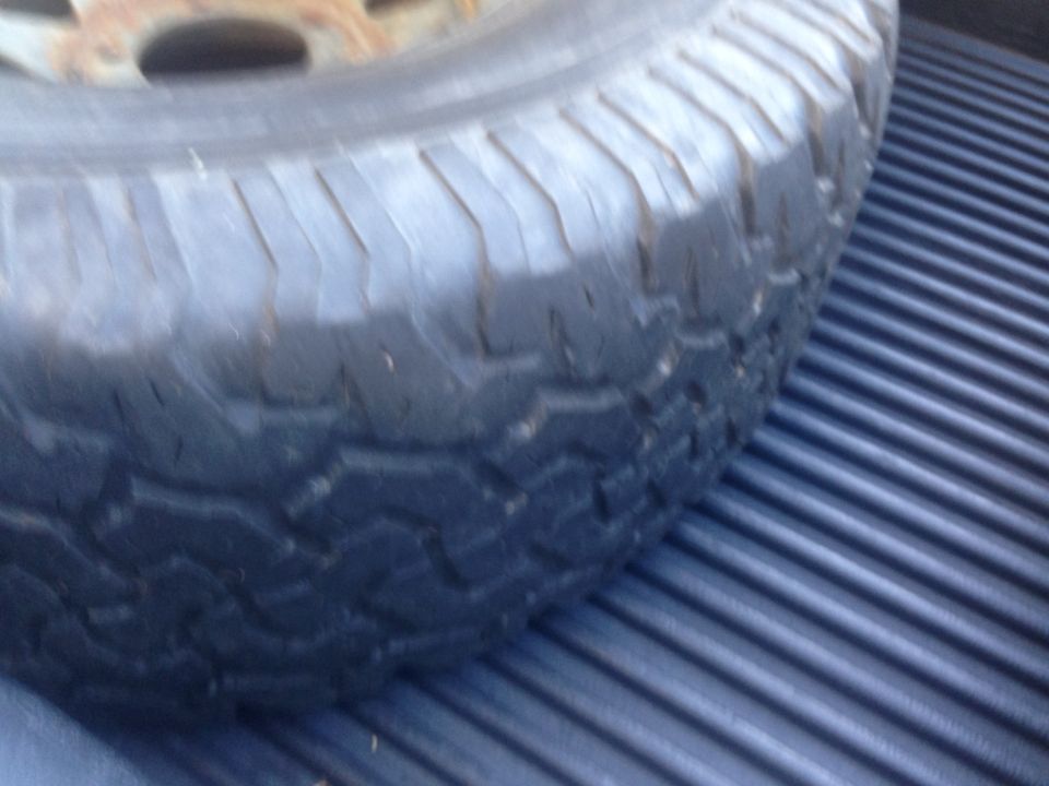 Spare tire resting on ribbed truck bed liner