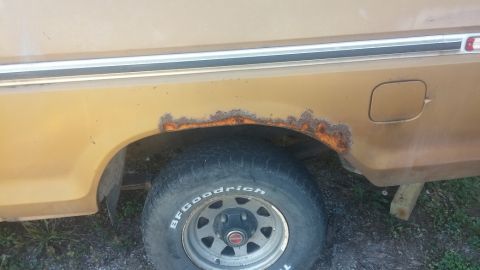 1979 Ford Bronco - This vehicle shows significant rust around the rear wheel well and has a fuel door on the rear quarter panel.