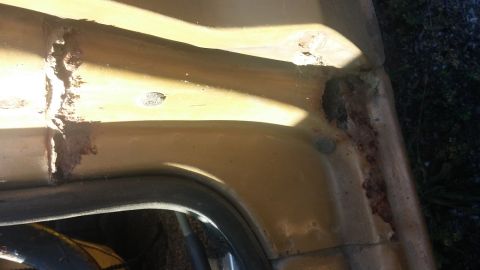 1979 Ford Bronco - This photo shows extensive rust damage on a vehicle's body panel, indicating a need for repair.