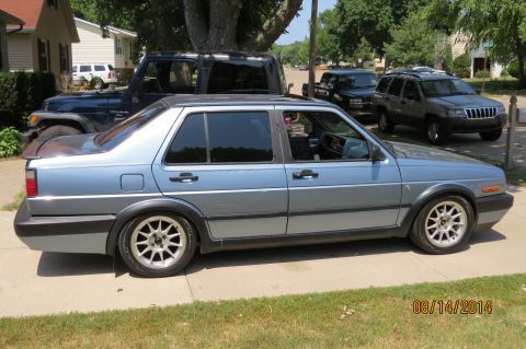 1985 Volkswagen GTI - A light blue Volkswagen sedan is parked on a driveway, with other vehicles in the background.