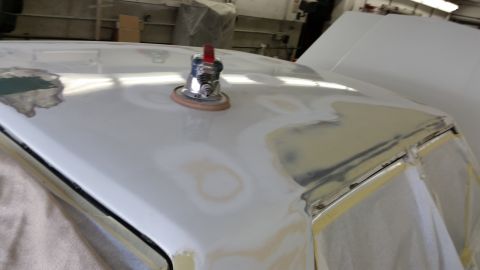 1991 Ford LTD Crown Victoria - A car roof is being prepped for paint, showing areas of body filler and sanding.