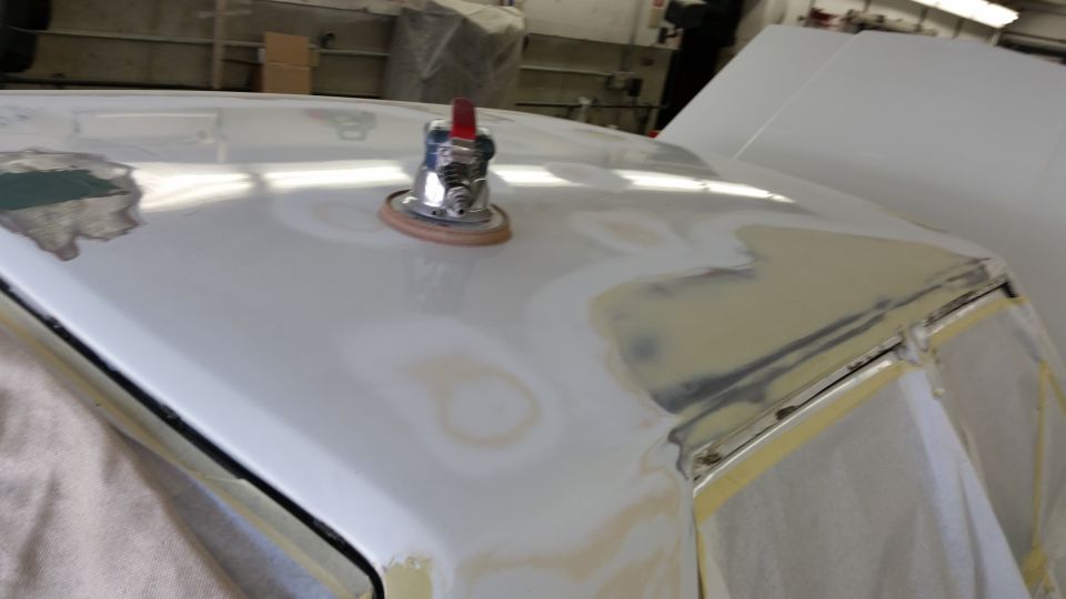 Car roof with sanding marks and primer, a polishing tool on top