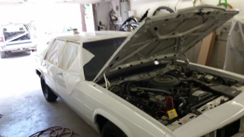 1991 Ford LTD Crown Victoria - 1991 Ford Crown Victoria LTD undergoing work in a garage, with its hood open and masking tape applied to the windows.