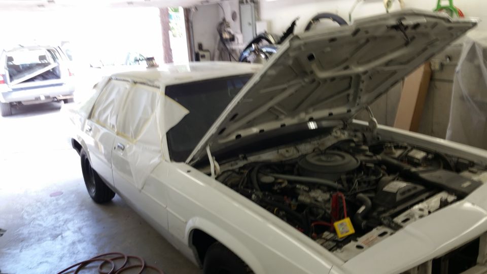 White 1991 Ford Crown Victoria LTD in garage with hood open, masking tape on windows. Another vehicle is parked behind it