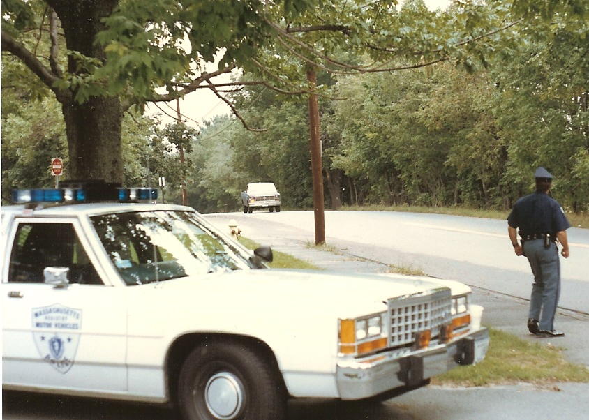 White 1991 Ford Crown Victoria LTD police car, 3q-front view, with visible Massachusetts Motor Vehicles badge