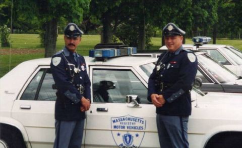 1991 Ford LTD Crown Victoria - Two Massachusetts Registry of Motor Vehicles officers stand beside a 1991 Ford Crown Victoria LTD police car, with other similar vehicles v…