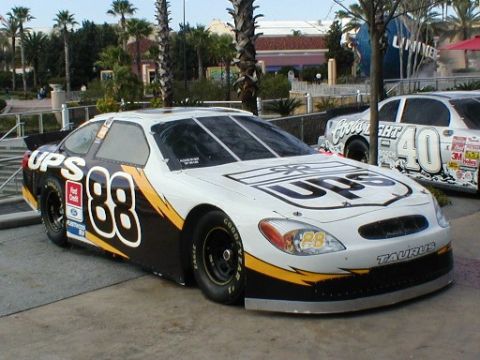 1979 Ford Bronco II - A white and black UPS race car with the number 88 is parked next to another race car.