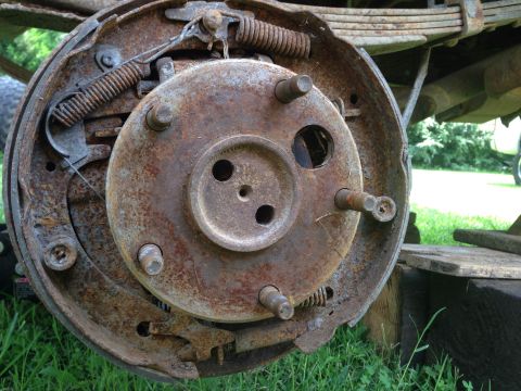 1979 Ford Bronco - Close-up of a heavily rusted brake drum assembly, showing internal components and springs.