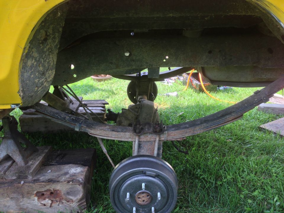 1979 Ford Bronco rear axle with leaf springs and brake drum, jack stands visible