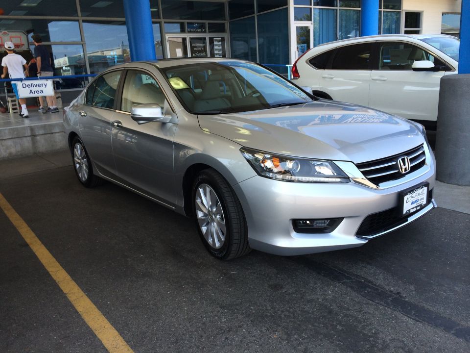 Silver 2014 Honda Accord sedan parked in front of a building, with a white SUV behind it
