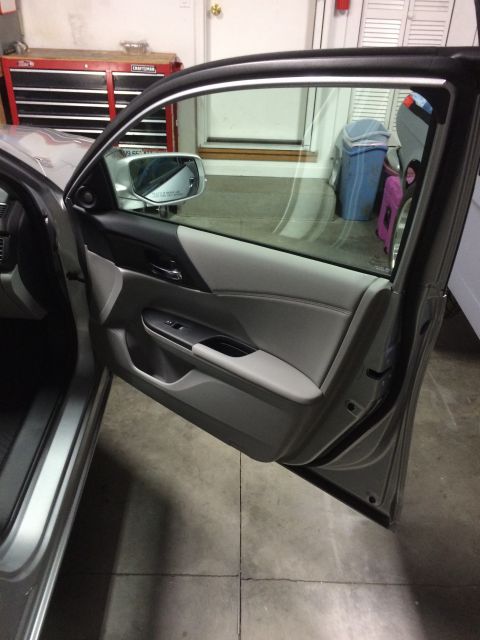 2014 Honda Accord - The interior door panel of a car is shown with the door open, revealing the car's interior and a garage setting.