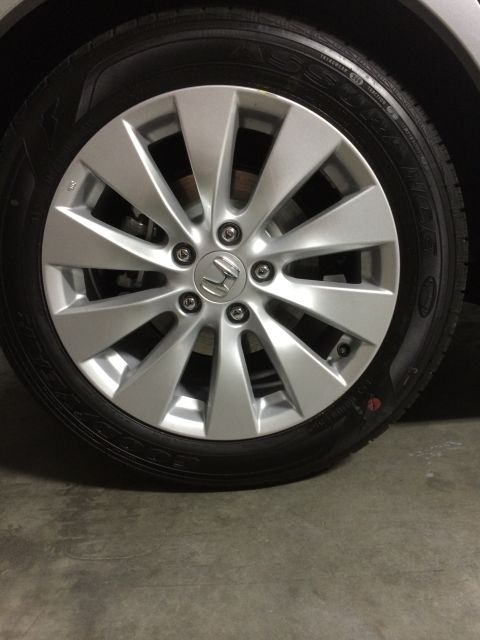 2014 Honda Accord - A close-up view of a silver Honda alloy wheel and tire, showing the vehicle's badge and tire details.