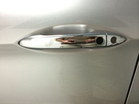 2014 Honda Accord - A close-up shot focuses on the chrome door handle of a vehicle, revealing a keyhole and a reflection.