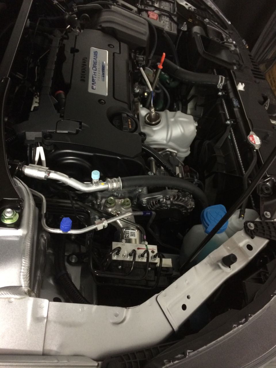 Engine bay of a 2014 Honda Accord, showing the Earth Dreams engine cover and various components